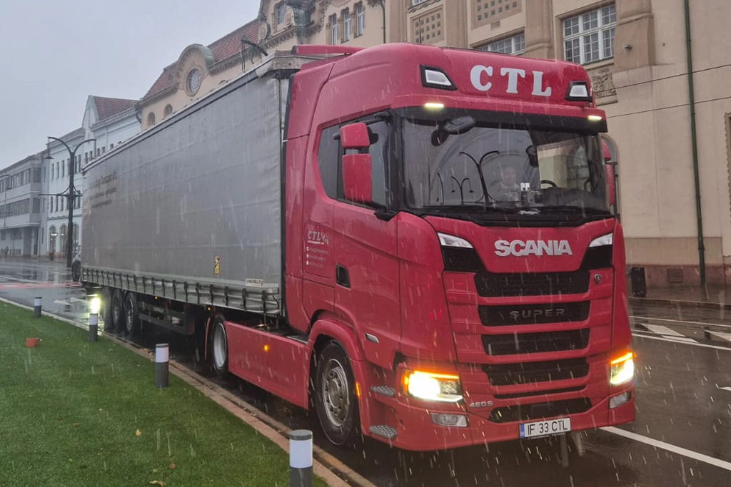 Ansamblu camion si semiremorca cu prelata in centrul unui oras european